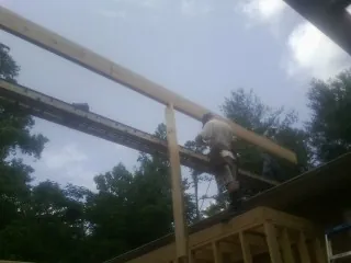 Carpenter setting a ridge beam over a new addition frame — Ice Dam Removal by Roofing Brothers in Pierre Part