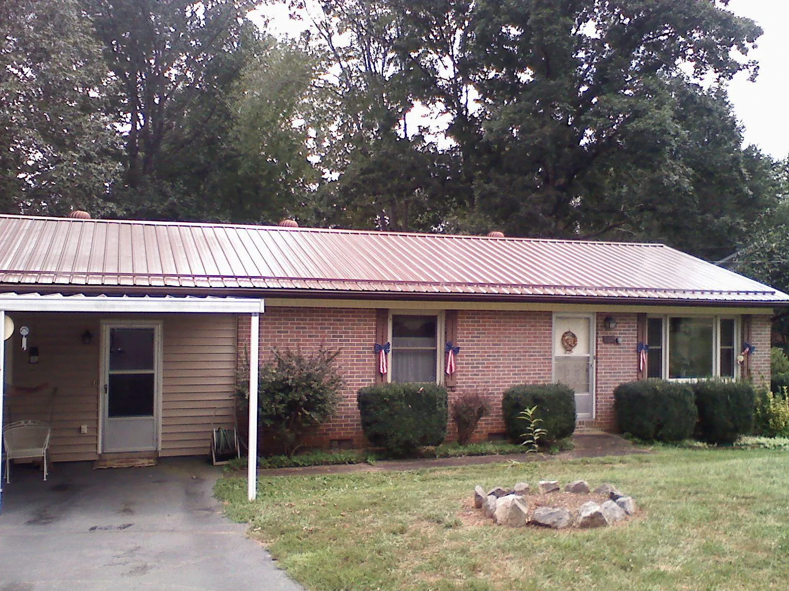 Bronze metal roof and carport on a brick ranch home — Roof Repair work by our crew in Pierre Part