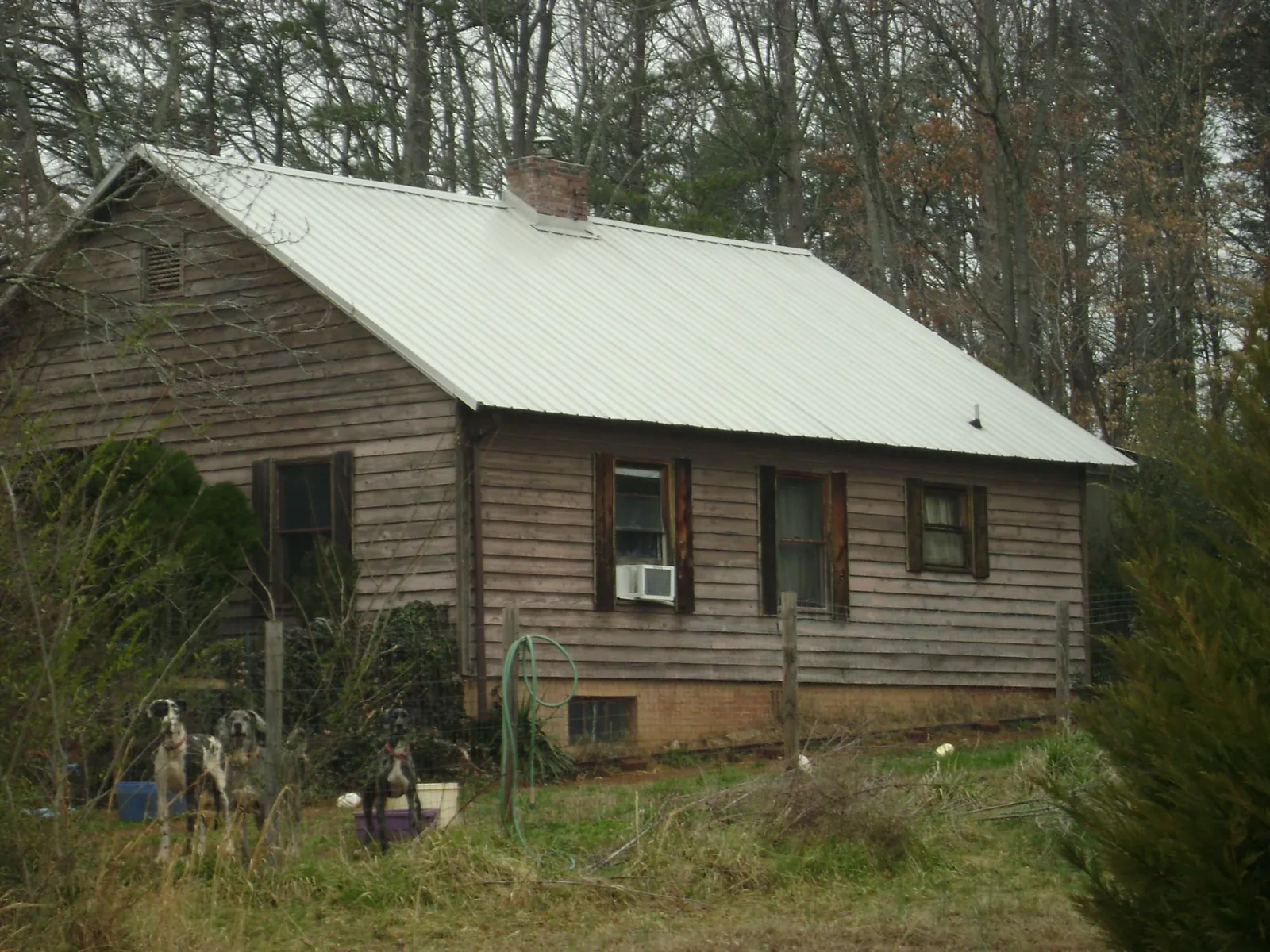 White metal roof on an old wood sided farmhouse, from a Metal Roof Installation job in Pierre Part